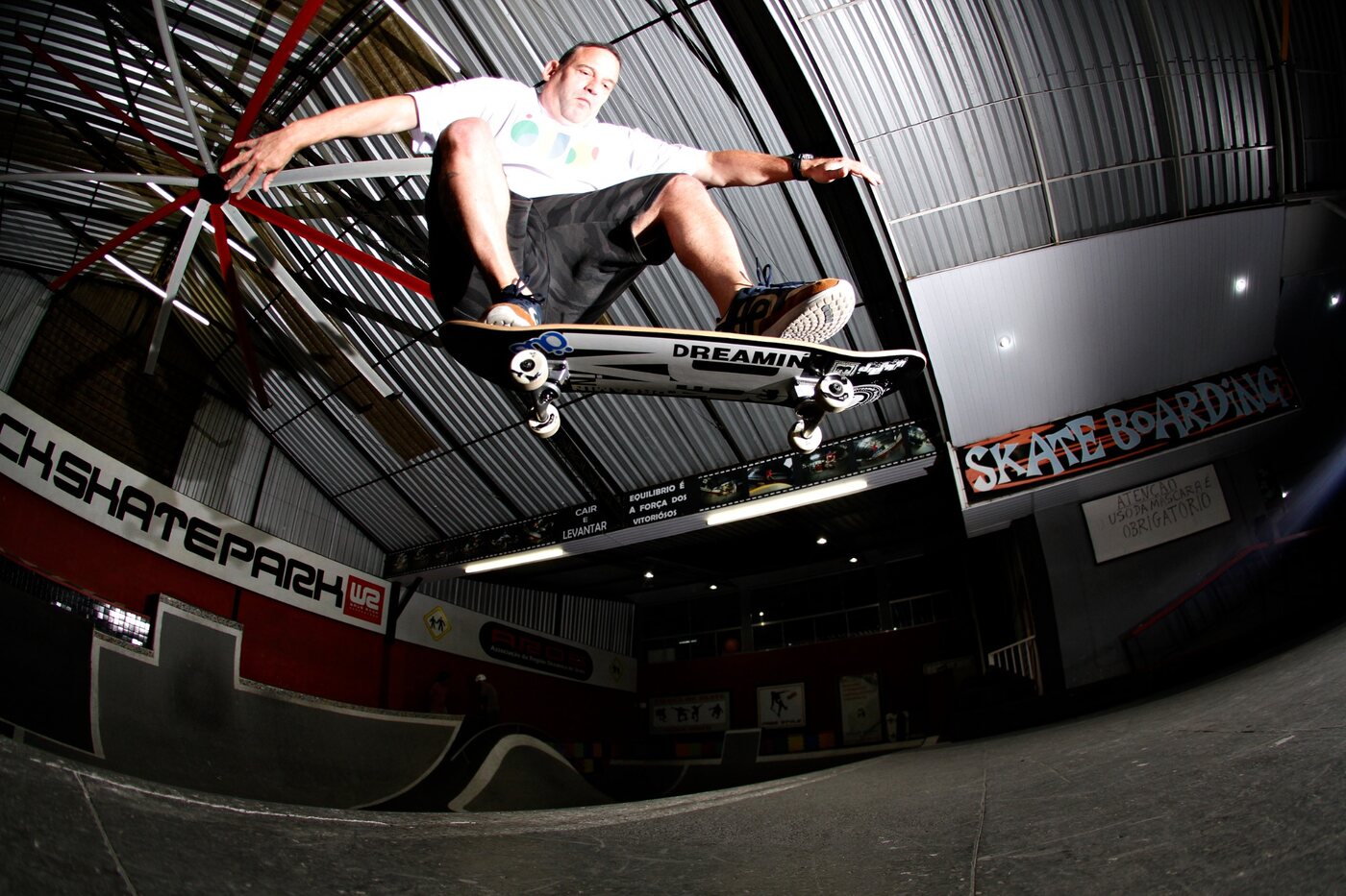 Ronnie performing a skateboard trick at an indoor skatepark